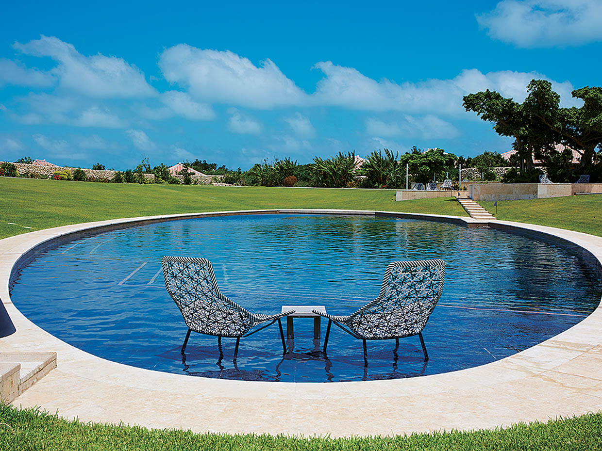 集落の中央にあるすり鉢状のプール。青空の下、泳いだり、プールサイドでまどろんだり、夜は満天の星を眺めたり、おのおのが好きなように利用