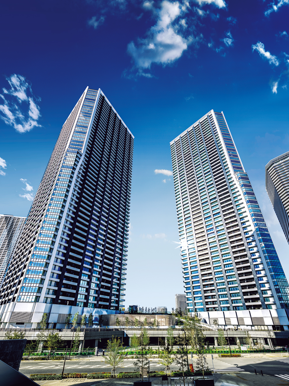 都心と湾岸が交差する街・晴海で、ひときわ存在感を放つ外観。ガラスカーテンウォールとシャープな造形。※平成27年11月撮影の竣工写真