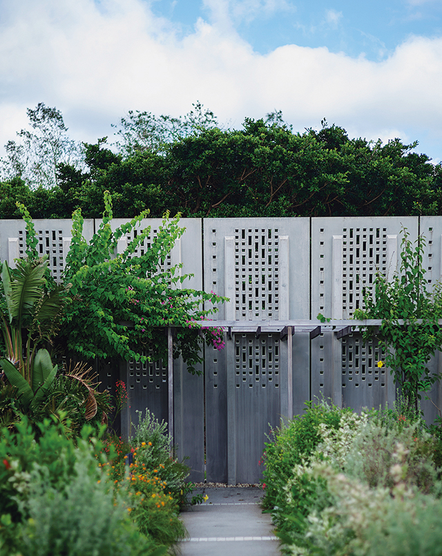 星のや沖縄。グスクウォールをくぐると色彩豊かな植物が生い茂る